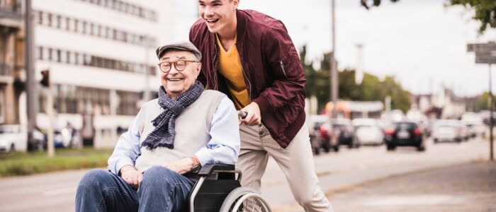 Boy pushing grandfather in wheelchair