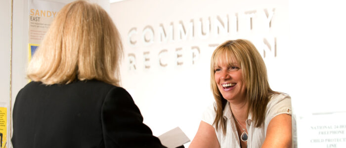 A woman being greeted at the Community Centre reception