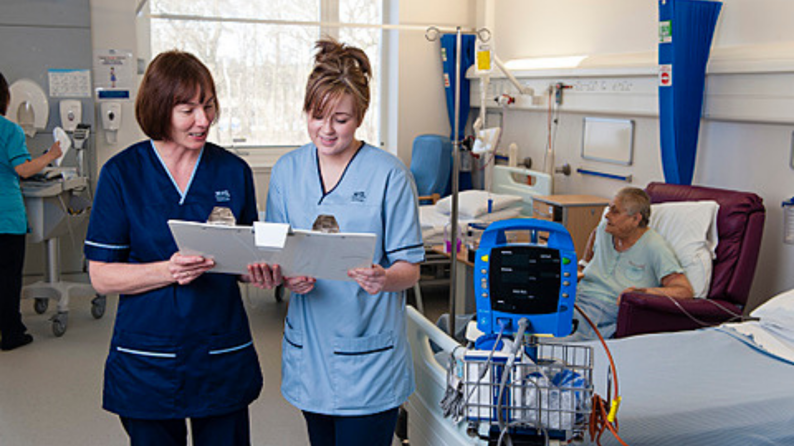 NHS staff discussing patient in ward